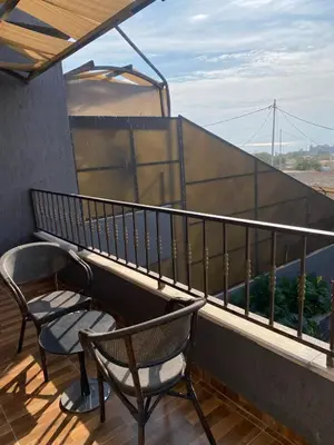 a balcony with two chairs and a table and a railing at SAN VITO Chalet in Sowayma