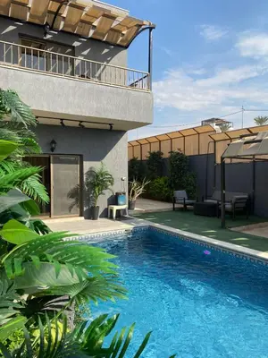 a swimming pool in front of a house at SAN VITO Chalet in Sowayma