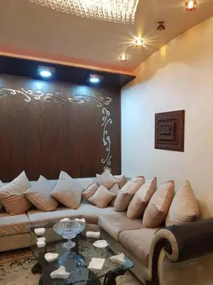 a living room with a large couch and a table at Coazmatic apartment in Kerak