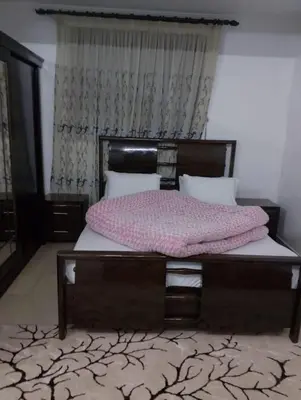 a bedroom with a large bed with a wooden frame at Coazmatic apartment in Kerak