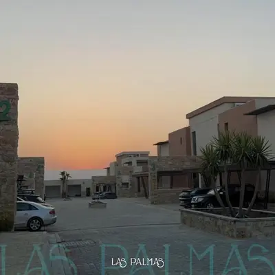 a parking lot with cars parked in front of buildings at Las palmas resort in Sowayma
