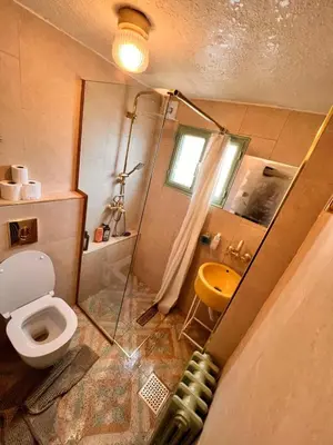 a bathroom with a toilet and a sink and a shower at Amman Antique Penthouse in Amman