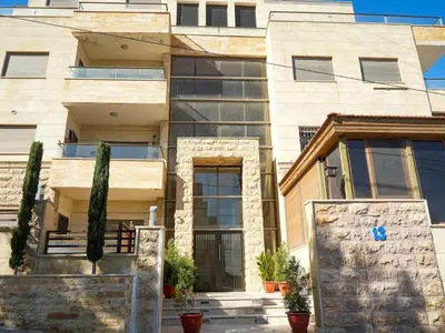 a large building with plants in front of it at Yafa 2BR N Abdoun Apartment in Amman