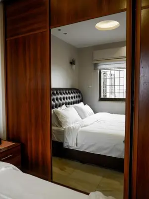 a bedroom with a bed and a large mirror at Yafa 2BR N Abdoun Apartment in Amman