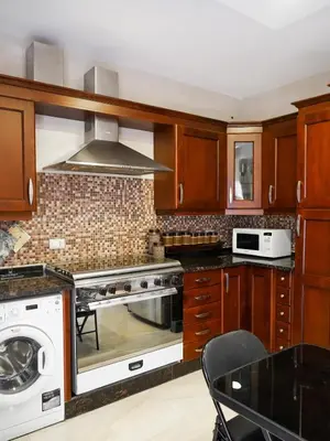 a kitchen with a stove and a microwave at Yafa 2BR N Abdoun Apartment in Amman