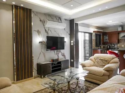 a living room with two chairs and a television at Yafa 2BR N Abdoun Apartment in Amman
