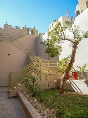 a staircase with a tree in front of a building at Yafa 2BR N Abdoun Apartment in Amman