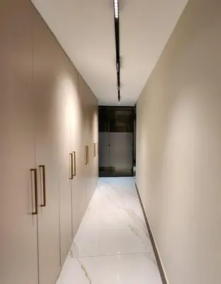 an empty corridor with white walls and a hallway with doors at Halimah 3BR Luxury Apt-Der Ghbar in Amman