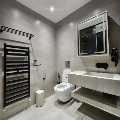 a bathroom with a toilet and a sink and a window at Halimah 3BR Luxury Apt-Der Ghbar in Amman