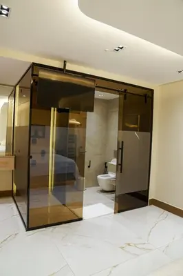 a bathroom with a glass door leading to a bedroom at Halimah 3BR Luxury Apt-Der Ghbar in Amman