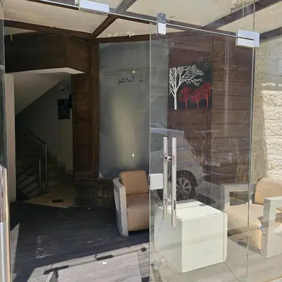 a glass door with a chair and a table at Cozy apartment in Amman