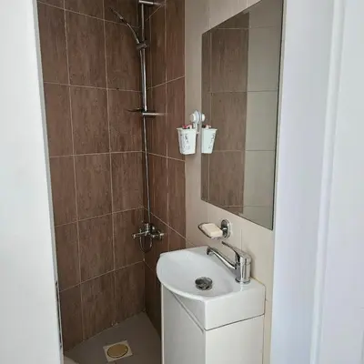 a small bathroom with a sink and a shower at Cozy apartment in Amman