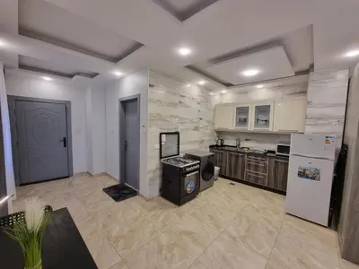 a large kitchen with white appliances and a refrigerator at Sama Dier Ghbar 1 in Amman