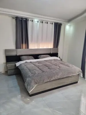 a bedroom with a large bed with a wooden headboard at Sama Dier Ghbar 1 in Amman