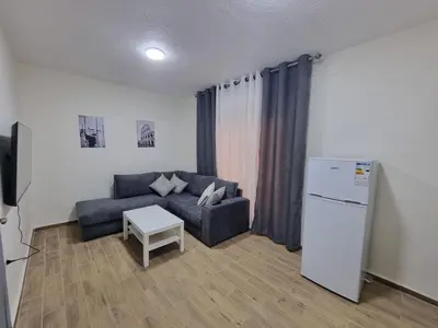 a living room with a couch and a refrigerator at Sama Dier Ghbar 1 in Amman
