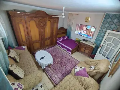 a small living room with a couch and a tv at Zarmot INN in Az Zarqa