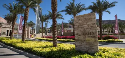 a sign at the entrance of a resort with palm trees at Al RAHA village - Aqaba أستوديو بقرية الراحه العقبة مرسى زايد in Aqaba