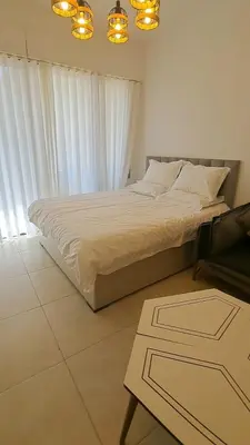 a bedroom with a large bed with white curtains at Al RAHA village - Aqaba أستوديو بقرية الراحه العقبة مرسى زايد in Aqaba