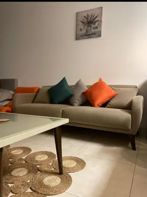 a living room with a couch with colorful pillows at Al RAHA village - Aqaba أستوديو بقرية الراحه العقبة مرسى زايد in Aqaba