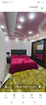 a bedroom with a large bed with a pink blanket at Mona villa in Irbid