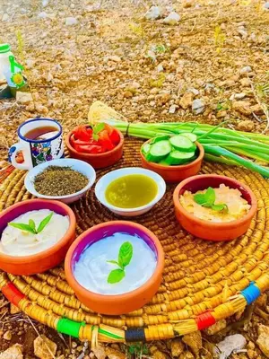 a table with bowls of dip and vegetables on it at Nassen House in Udhruḩ
