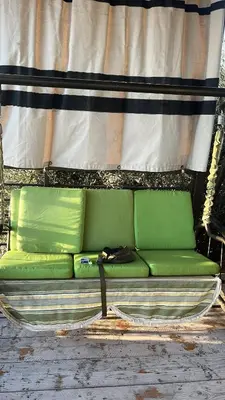 a green couch sitting in front of a curtain at Olive house in Um Qeis