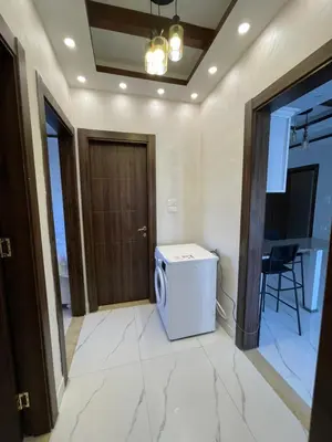 a room with a washing machine in a room with a door at Sawa Apartment in Amman