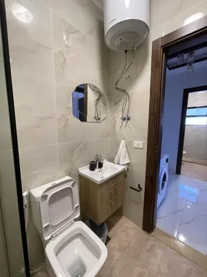 a bathroom with a toilet and a sink at Sawa Apartment in Amman