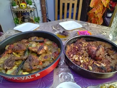 two pans of food sitting on a table at Poster apartment in Maḩaţţat Jurf ad Darāwīsh