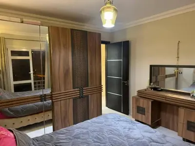 a bedroom with a bed and a mirror and a tub at Poster apartment in Maḩaţţat Jurf ad Darāwīsh