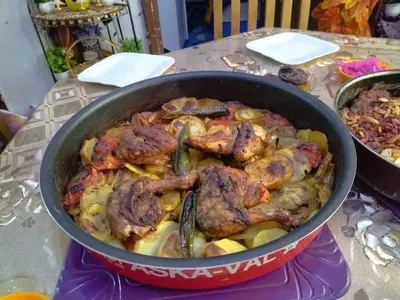 a pan filled with meat and vegetables on a table at Poster apartment in Maḩaţţat Jurf ad Darāwīsh