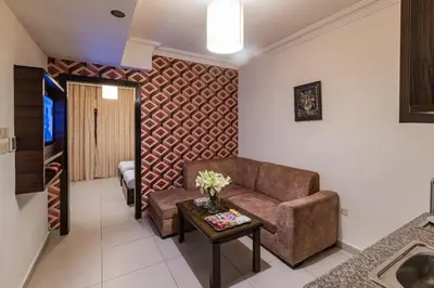 a living room with a couch and a table at Lancaster Hotel Apartments-Gardens in Amman
