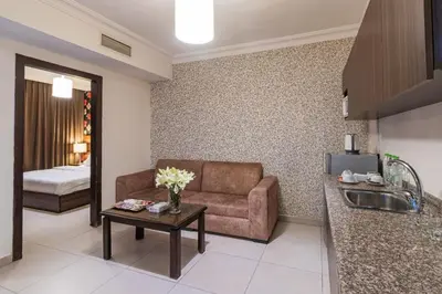 a living room with a couch and a table at Lancaster Hotel Apartments-Gardens in Amman