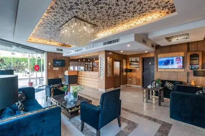 a living room with blue furniture and a tv at Lancaster Hotel Apartments-Gardens in Amman