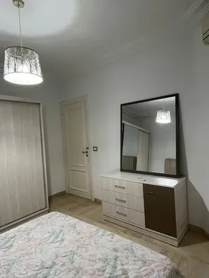 a room with a large mirror and a dresser with a television at carfort House in Al Jafr