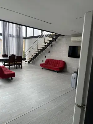 a living room with a red couch and stairs at the royal occasion amman in Amman