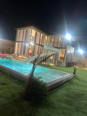 a building with a swimming pool at night at the royal occasion amman in Amman