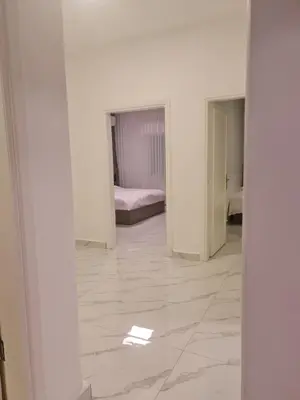 a room with white walls and a room with a bed at Layal's apartment in Amman