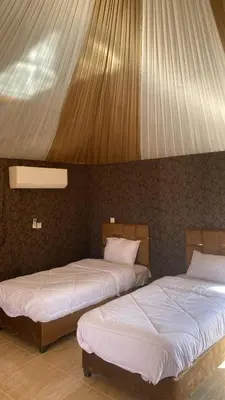 two beds sitting next to each other in a room at Amin Camp in Wadi Rum