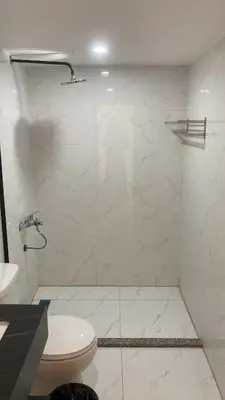a white bathroom with a shower and a toilet at Amin Camp in Wadi Rum
