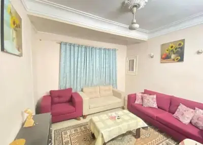 a living room with two purple couches and a table at jarmy house in Ash Shajarah