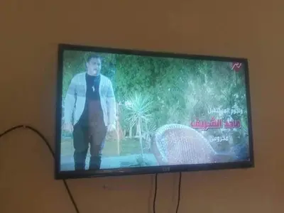 a television screen with a man standing on it at jarmy house in Ash Shajarah