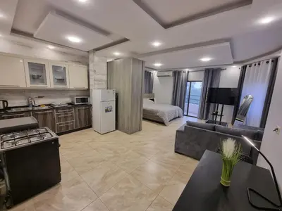 a kitchen and living room with a couch and a bed at Sama Dier Ghbar 5 in Amman