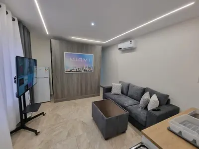 a living room with a couch and a flat screen tv at Sama Dier Ghbar 6 in Amman