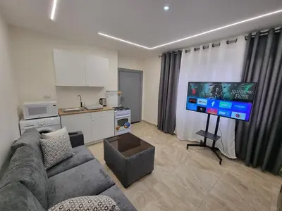 a living room with a couch and a flat screen tv at Sama Dier Ghbar 6 in Amman