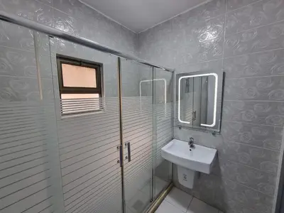 a bathroom with a sink and a glass shower at Sama Dier Ghbar 6 in Amman