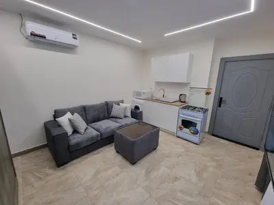 a living room with a couch and a kitchen at Sama Dier Ghbar 6 in Amman