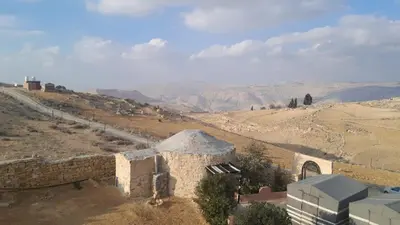 a view of a desert with a building in the foreground at Dana local Life Eco lodge in At-Tafilah