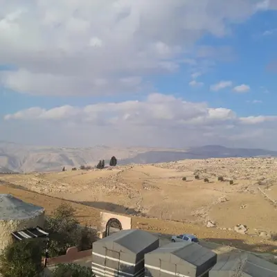 a view of a desert with a building in the foreground at Dana local Life Eco lodge in At-Tafilah
