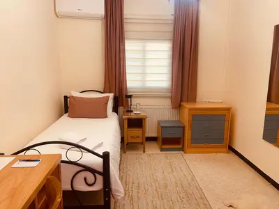 a bedroom with a bed and a desk and a window at Baytna Hotel in Petra